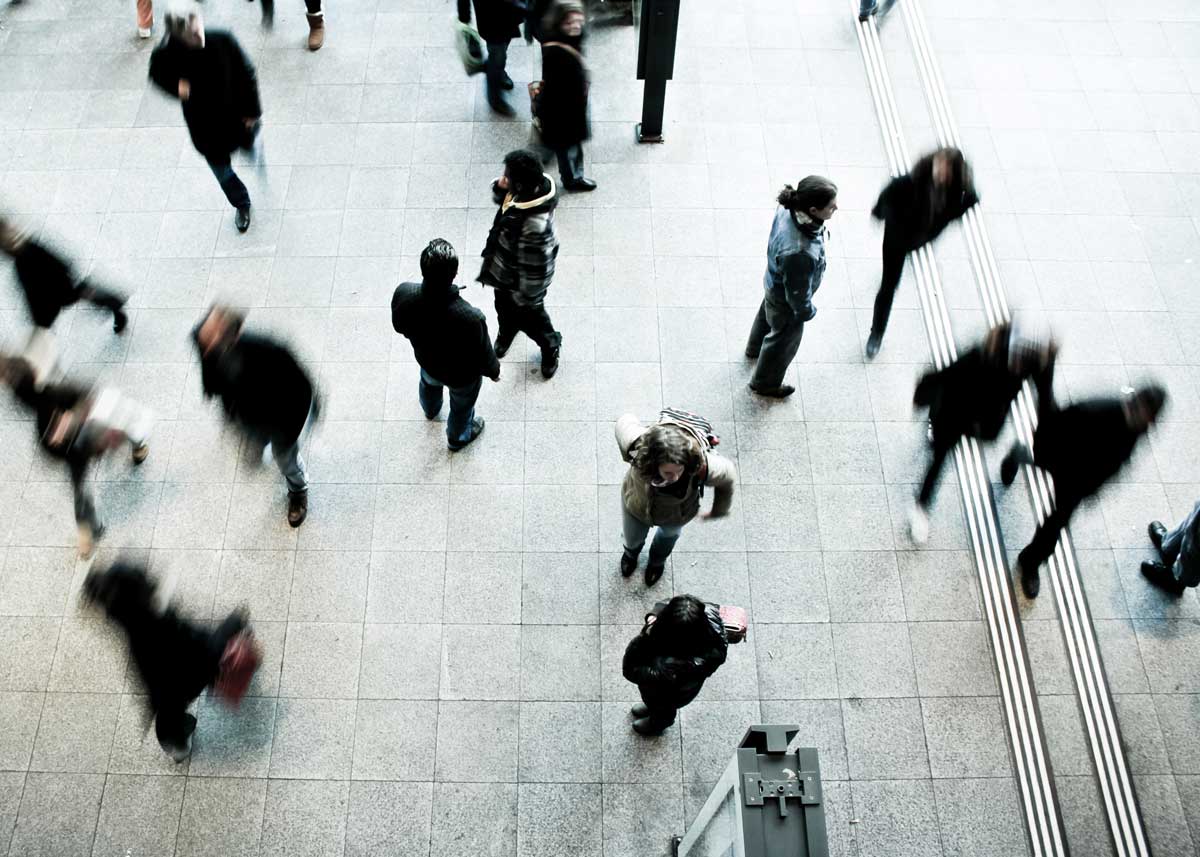 Aerial view of individuals walking in all 4 directions in what appears to be busy urban centre